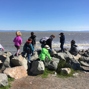 Children climbing over rocks on bayside jetty